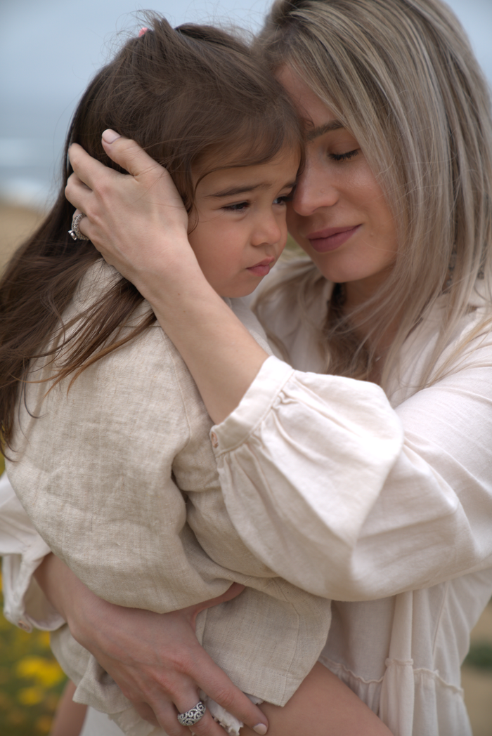 Heartfelt moment capturing a mother embracing her daughter warmly in an outdoor setting.